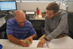 Photo of two mechanical engineers reviewing technical drawings